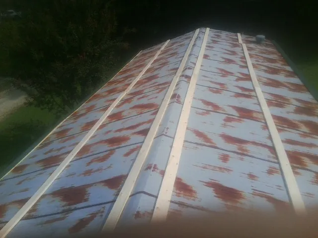 Rusted metal roof panels with new wood purlins before replacement — Storm Damage Roof Repair in Omega by Roofing Brothers